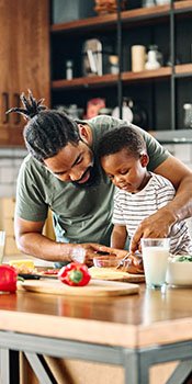An African-American dad makes a healthy meal with his son