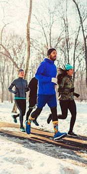 a group of runners run on a snowy trail