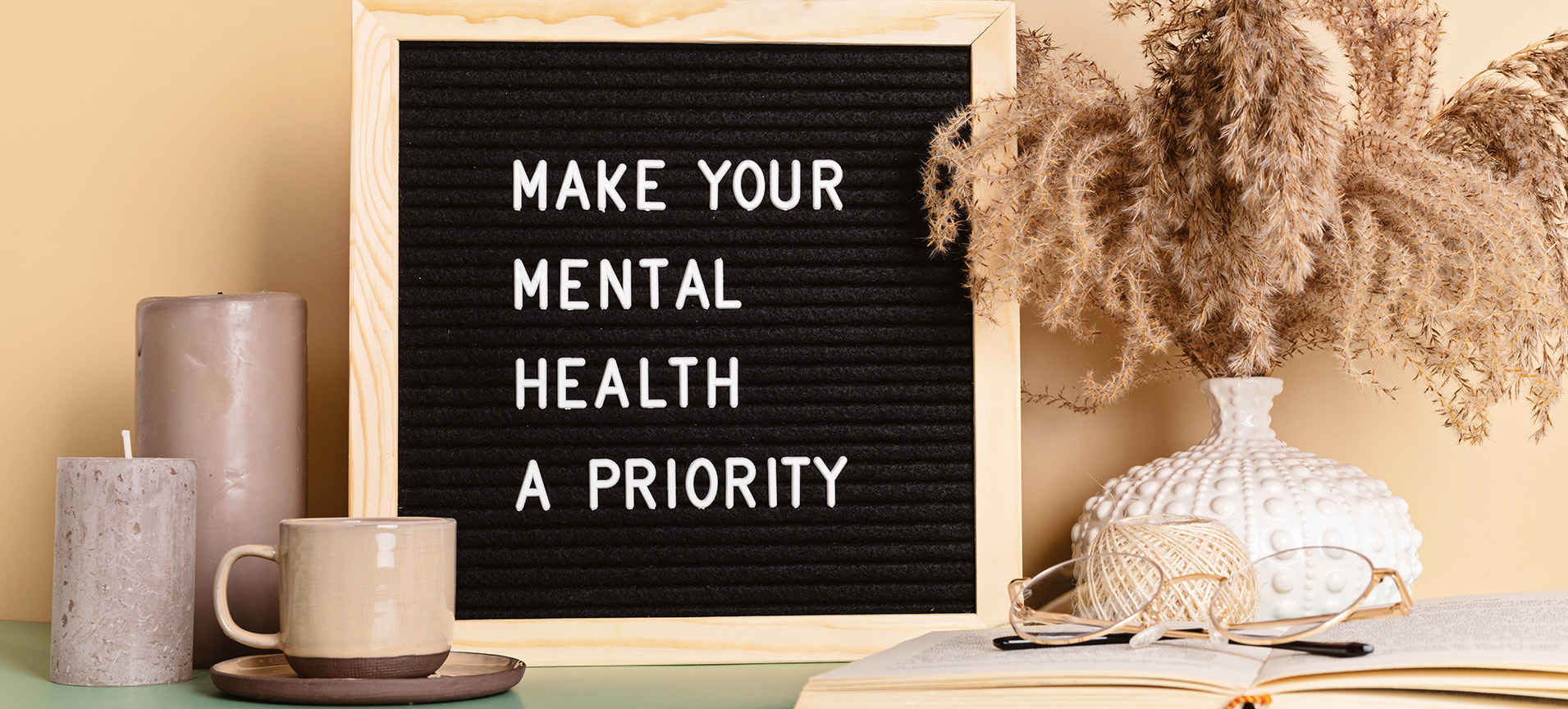 a counter with mugs, flowers, glasses and a marquis sign that read: Make Your Mental Health a Priority