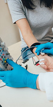 a doctor conducts an emg test on a patient's arm