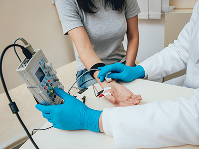 a doctor does an emg test on a patient's arm