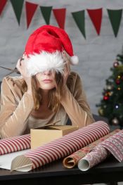 frustrated woman wrapping Christmas gift boxes