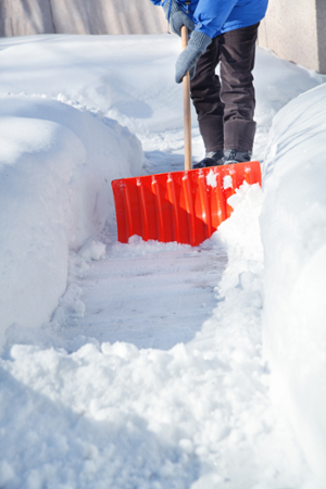 person shoveling pile of heavy snow